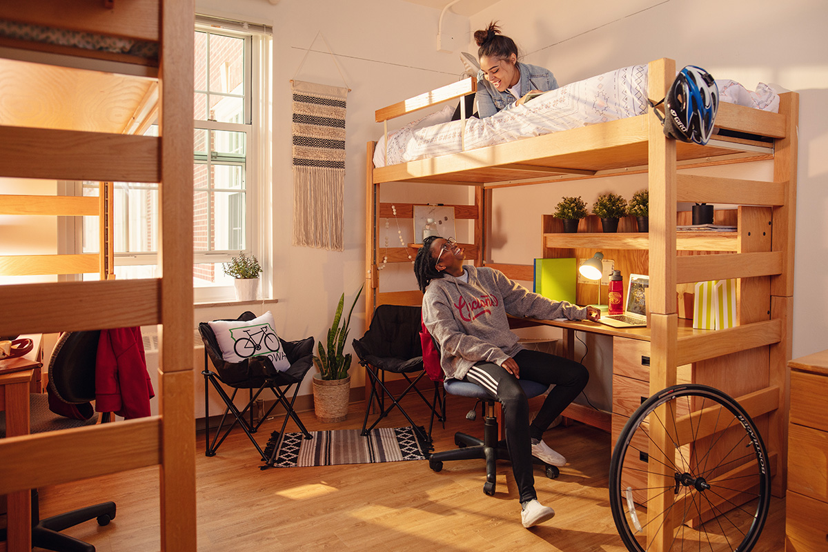 Two students lounging in a residence hall room