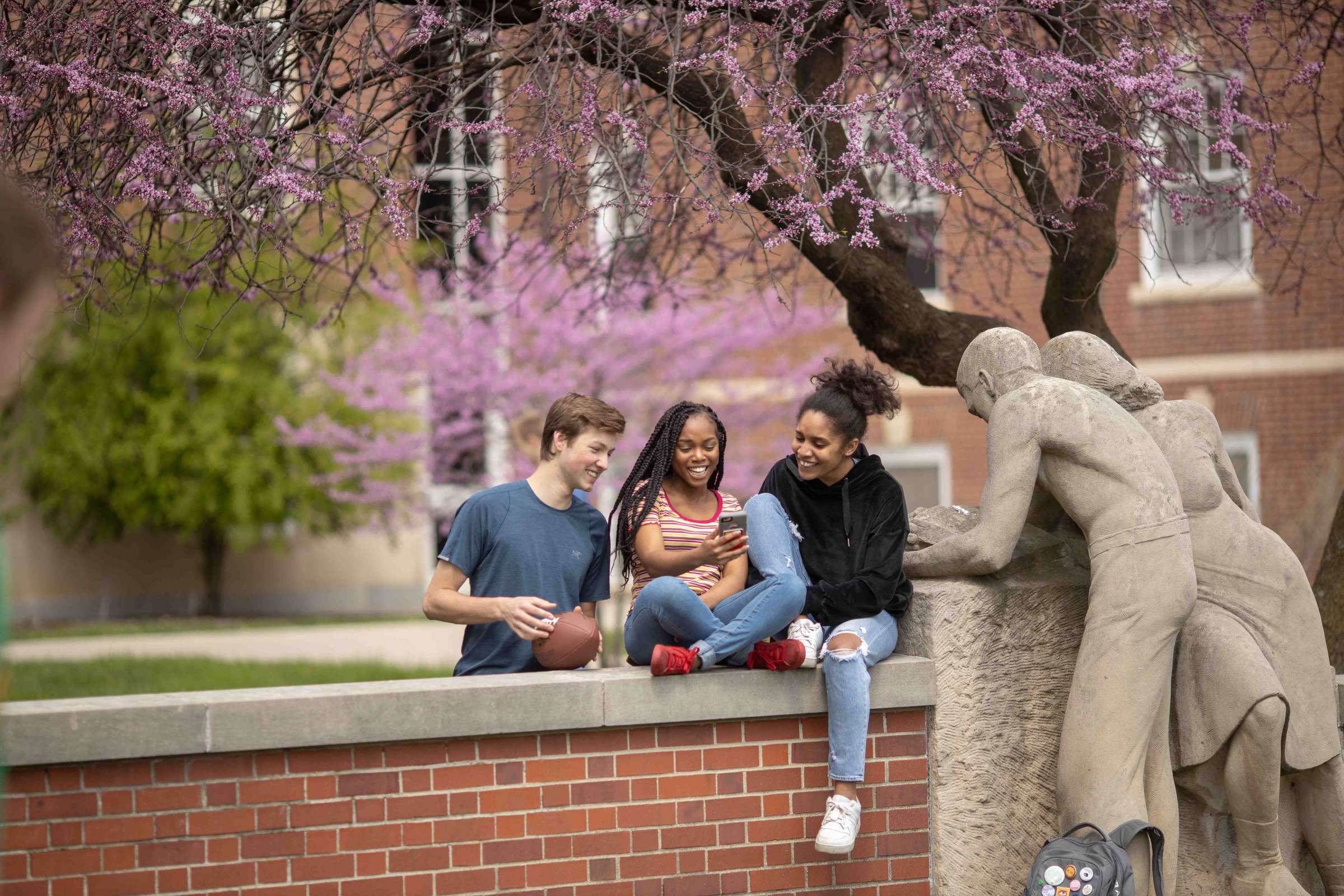 A group of students lounging outside of the Conversations entrance of Oak-Elm