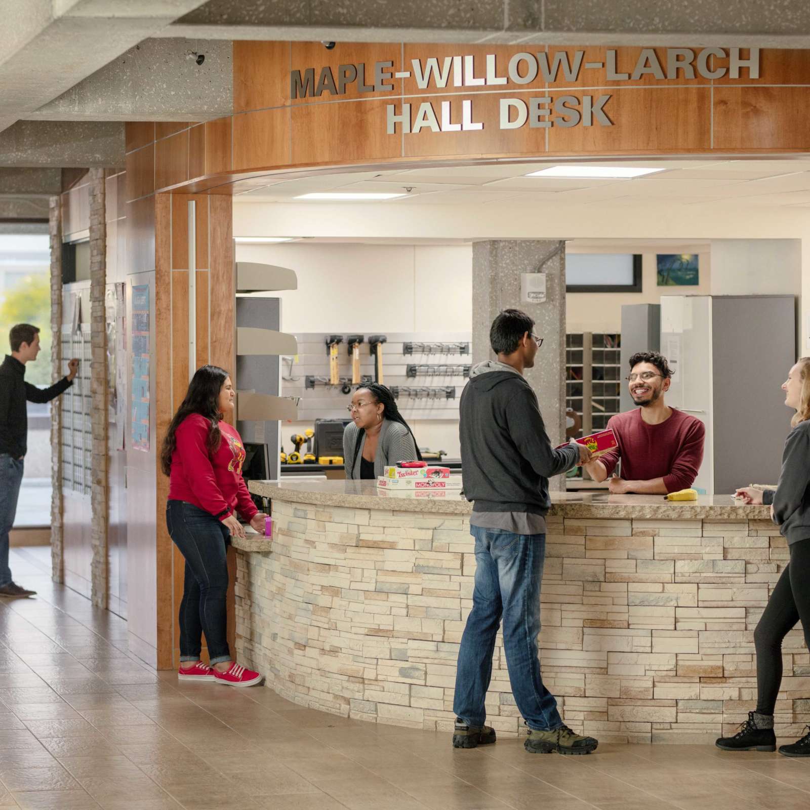 Students talking and working at the Maple-Willow-Larch Hall Desk